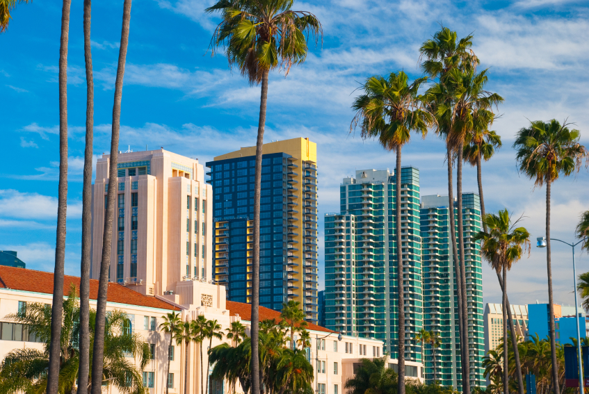 The San Diego County Administration building, and modern condominium towers in the background, with palm trees in the foreground.